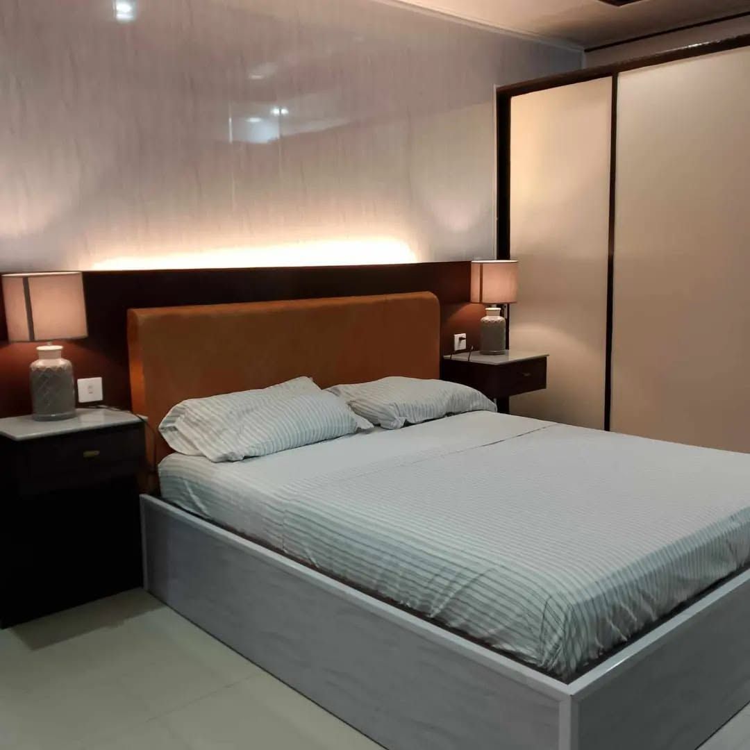 Queen Room with a timber headboard, backlit wall, bedside lamps and a full-height wardrobe